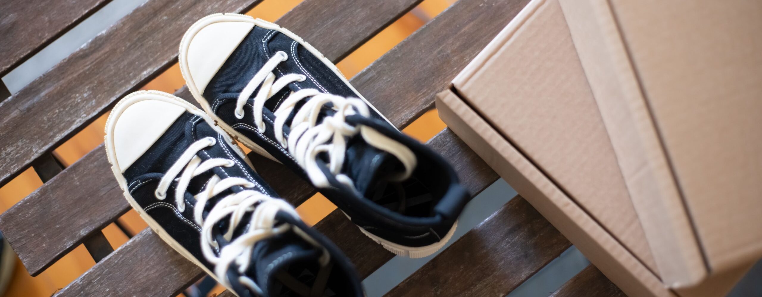 Stylish high top sneakers on a rustic wooden bench with cardboard boxes. Perfect for fashion shoots.